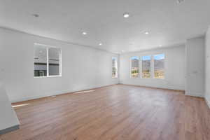 Unfurnished room featuring a textured ceiling and light wood-type flooring