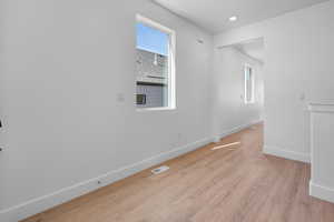 Empty room with light hardwood / wood-style floors