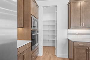 Kitchen featuring backsplash, stainless steel appliances, and light hardwood / wood-style flooring