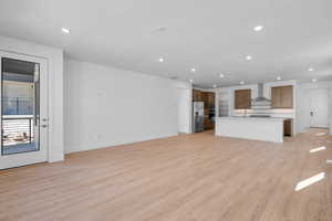 Unfurnished living room with sink and light hardwood / wood-style flooring