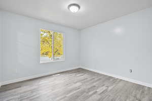 Empty room with light hardwood / wood-style flooring