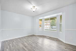 Spare room with a textured ceiling and light hardwood / wood-style flooring