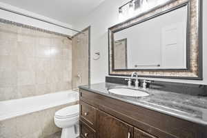 Full bathroom featuring vanity, toilet, and tiled shower / bath