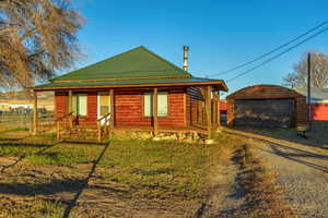 Log cabin featuring a garage, an outbuilding, and a front yard