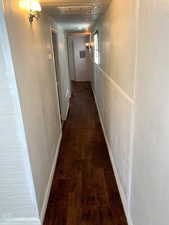 Corridor with dark hardwood / wood-style flooring