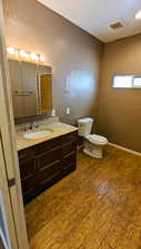 Bathroom featuring vanity, wood-type flooring, and toilet