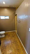 Bathroom with hardwood / wood-style flooring and toilet