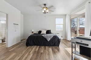 Bedroom featuring ceiling fan, wood-type flooring, and ensuite bath