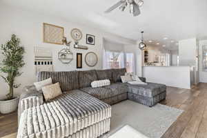 Living room with ceiling fan and light hardwood / wood-style flooring