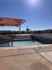 View of swimming pool featuring pool water feature and a patio