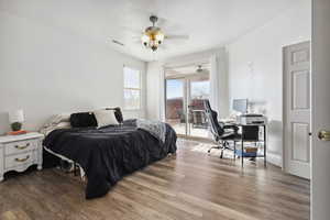 Bedroom featuring ceiling fan, a textured ceiling, hardwood / wood-style flooring, and access to outside