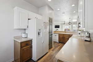 Kitchen featuring white appliances, a textured ceiling, white cabinetry, sink, and ceiling fan