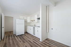 Kitchen with dark hardwood / wood-style floors, white refrigerator, white cabinetry, and sink