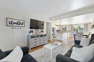 Living room featuring washer / dryer and light hardwood / wood-style flooring