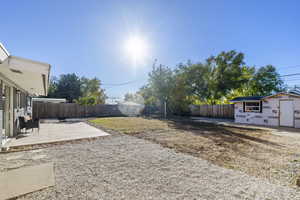 View of yard with a storage shed and a patio