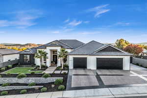 View of front of property featuring a mountain view, a front yard, and a garage