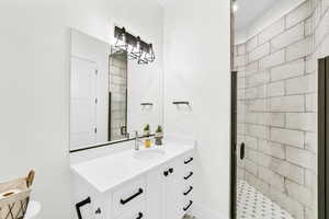 Bathroom featuring vanity and a shower with door