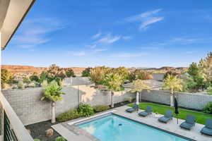 View of swimming pool featuring a mountain view and a lawn