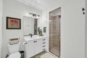 Bathroom featuring vanity, toilet, and a shower with shower door