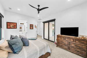 Bedroom with ceiling fan, light colored carpet, access to outside, and ensuite bath