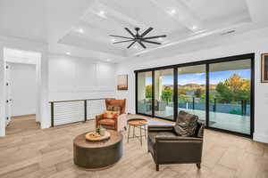 Sitting room featuring beamed ceiling, light hardwood / wood-style flooring, ceiling fan, and wooden ceiling