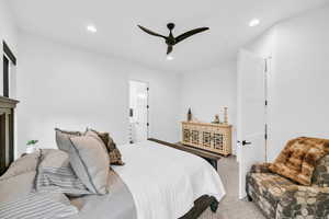 Carpeted bedroom featuring ceiling fan