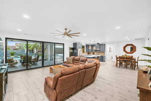 Living room with ceiling fan and light hardwood / wood-style flooring