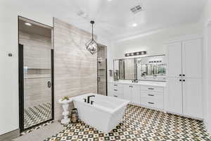 Bathroom with vanity, tile walls, and shower with separate bathtub