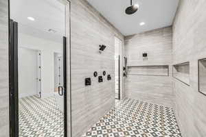 Bathroom featuring an enclosed shower and tile walls