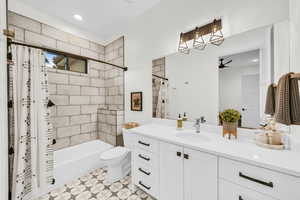 Full bathroom featuring vanity, ceiling fan, toilet, and shower / bathtub combination with curtain