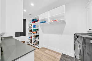 Walk in closet featuring light hardwood / wood-style floors and washing machine and clothes dryer