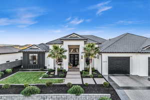 View of front facade featuring a garage, a front yard, and french doors