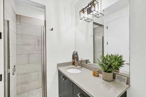 Bathroom featuring a shower with door and vanity