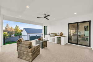 View of patio / terrace featuring an outdoor hangout area, sink, ceiling fan, a grill, and exterior kitchen