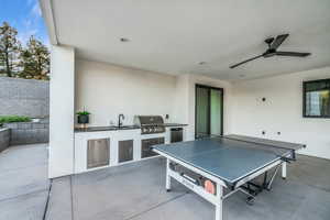 View of patio featuring a grill, area for grilling, sink, and ceiling fan