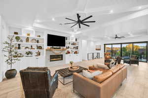 Living room featuring beam ceiling, built in shelves, ceiling fan, and light hardwood / wood-style floors