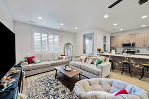 Living room with light hardwood / wood-style flooring and ceiling fan