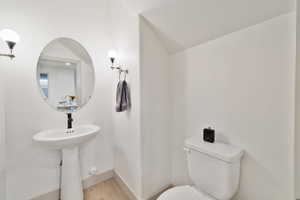 Bathroom with hardwood / wood-style flooring and toilet