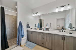 Bathroom featuring wood-type flooring, vanity, and curtained shower