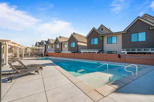 View of swimming pool with a pergola and a patio