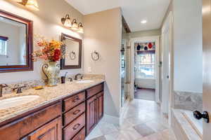 Bathroom featuring vanity and independent shower and bath