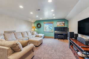 Carpeted living room with vaulted ceiling