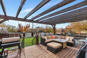 Deck with a yard, a storage unit, a pergola, an outdoor living space, and a playground