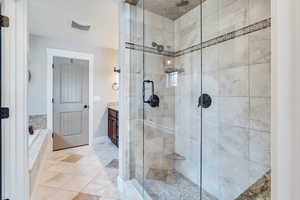 Bathroom with tile patterned flooring, vanity, and separate shower and tub