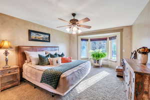 Carpeted bedroom with ceiling fan