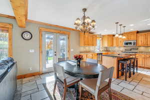 Dining space featuring french doors, an inviting chandelier, crown molding, and sink