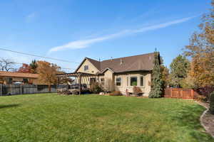 Rear view of house with a yard and a pergola