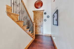 Foyer entrance featuring a towering ceiling and dark hardwood / wood-style flooring