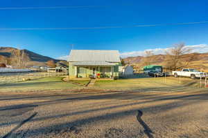 View of front facade featuring a mountain view, a porch, and a front yard