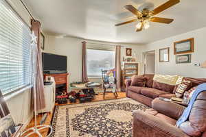 Living room with ceiling fan and light hardwood / wood-style floors